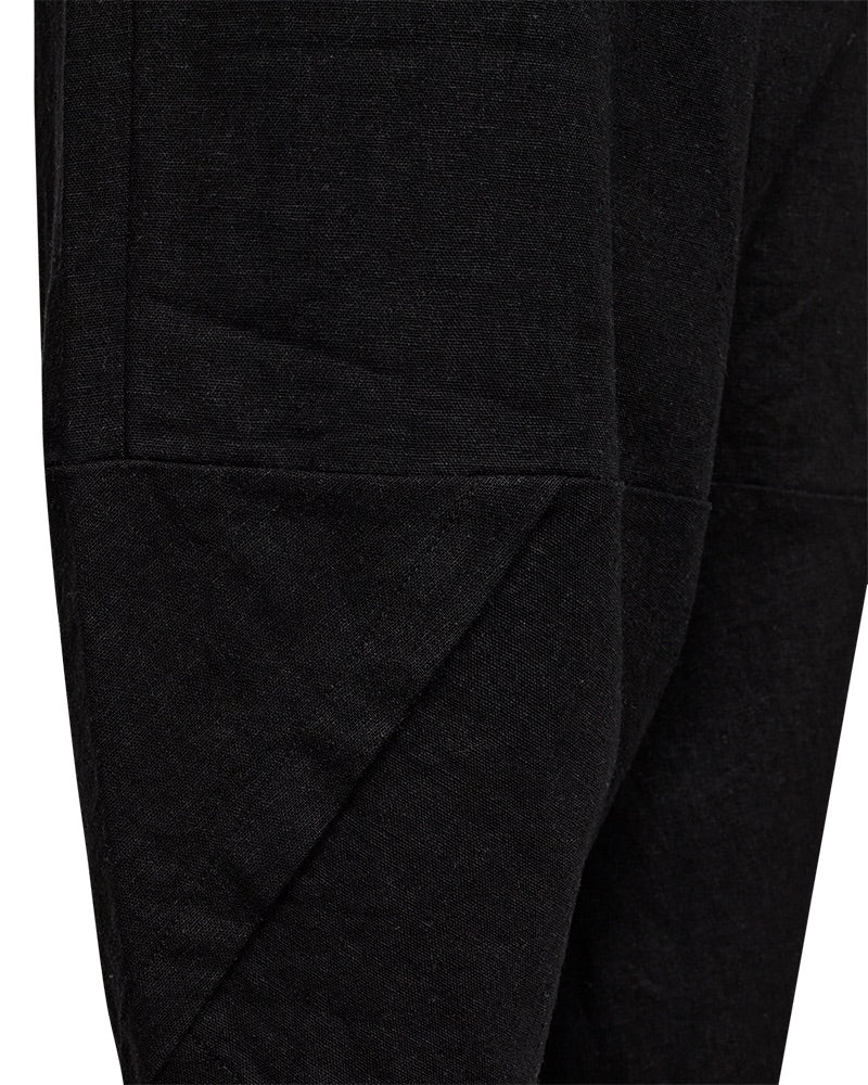 closeup af sorte bukser med elastik i taljen og bukseben med et asymmetrisk snit. Freequent Black FQLAVA-PANTS