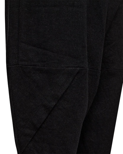 closeup af sorte bukser med elastik i taljen og bukseben med et asymmetrisk snit. Freequent Black FQLAVA-PANTS