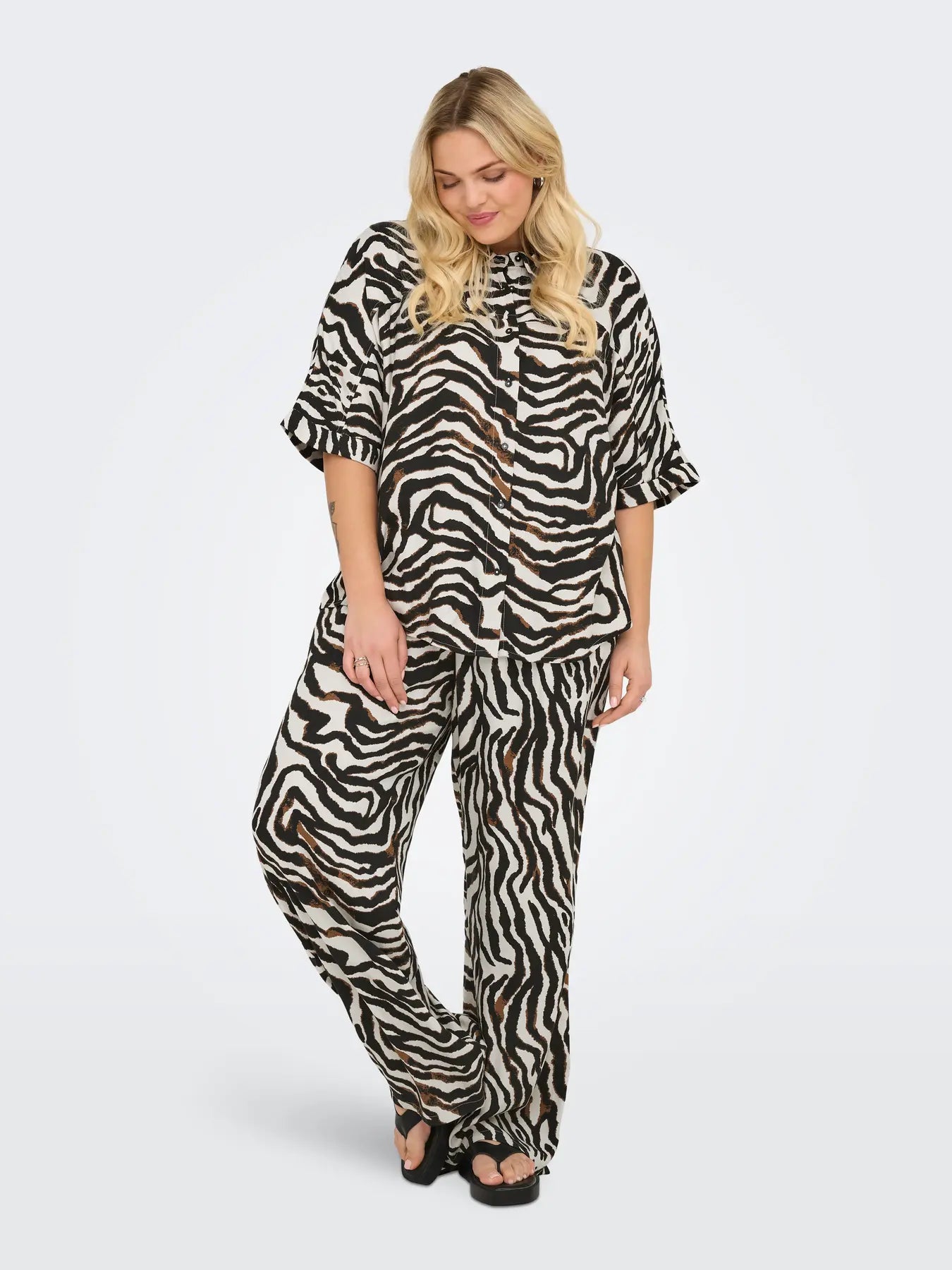 model med zebra bukser og kortærmet zebra skjorte med knaplukning. ONLY Carmakoma CARBERTE Shirt Pumice Stone Zebra